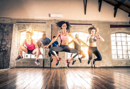 Group of sportive people training in a gym - Multi-ethnic group of athletes doing fitness